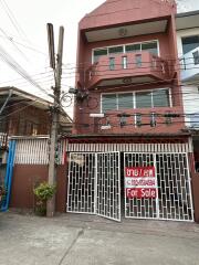 Front view of a multi-story house with a for sale sign