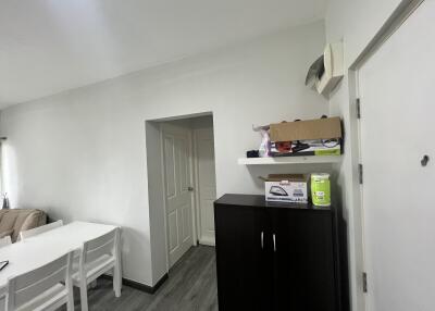 Living room with a white dining table, chairs, and a door visible.