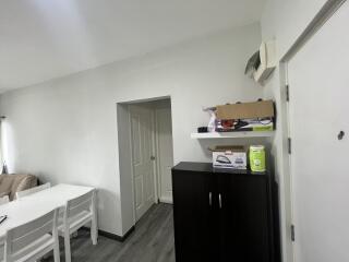 Living room with a white dining table, chairs, and a door visible.