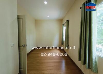 Empty bedroom with wooden floor and green curtains