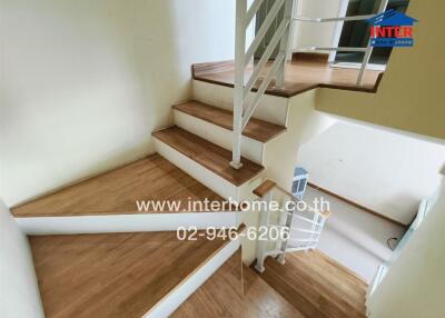Staircase with wooden steps and white railings