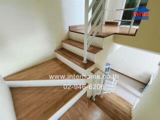 Staircase with wooden steps and white railings