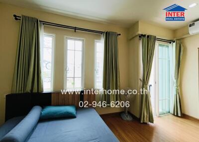 Bedroom with four windows, curtains, a bed, and air conditioning