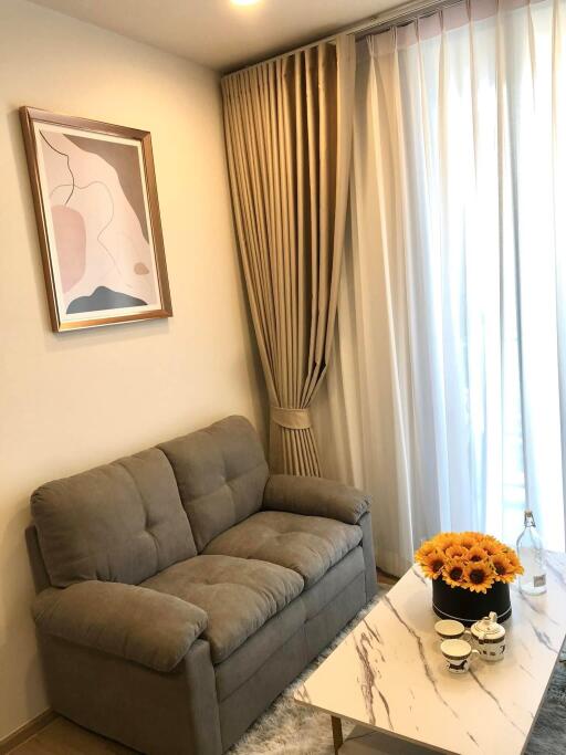 Cozy living room with a sofa, coffee table, and large window.