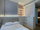 Modern bedroom with queen-size bed, built-in shelves, and mood lighting