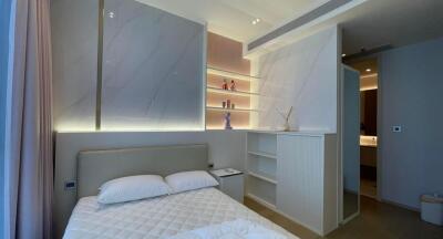 Modern bedroom with bed, shelves, and soft lighting