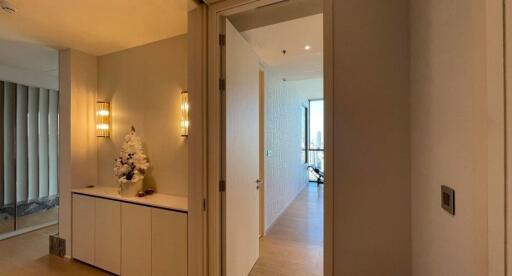 Hallway with modern lighting and storage cabinet leading to a room with large windows
