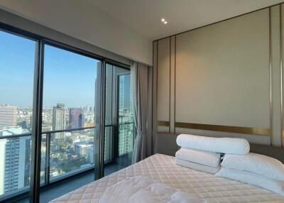 Modern bedroom with city view through large windows