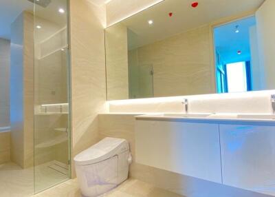 Modern bathroom with large mirror, double sink, and walk-in shower