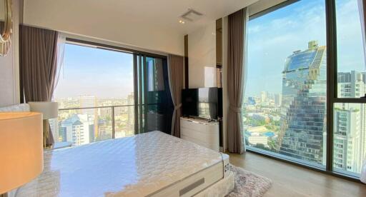 Modern bedroom with large windows offering a city view.