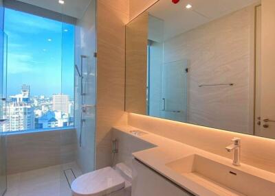 Modern bathroom with city view, large mirror, and vanity
