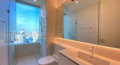 Modern bathroom with city view, large mirror, and vanity