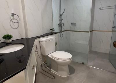 Modern bathroom with glass shower enclosure and black countertop