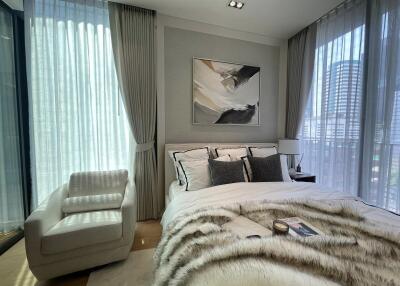 Modern bedroom with large windows, plush bedding, and elegant decor