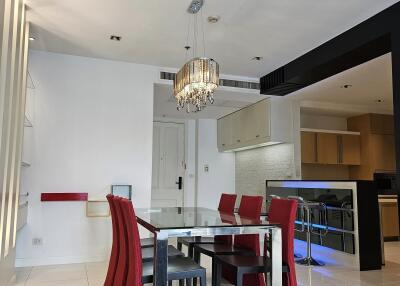 Modern dining area with chandelier and adjacent kitchen