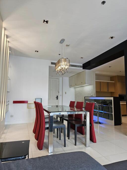 Modern dining area with chandelier and adjacent kitchen