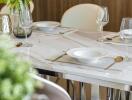 Elegant dining table set with plates, glasses, and cutlery