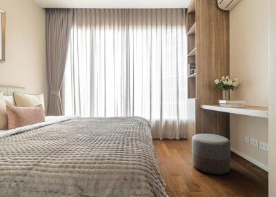 Modern bedroom with a large bed, grey bedding, and a study nook with a desk