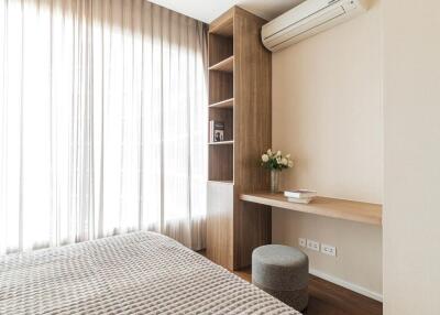 Well-lit bedroom with built-in shelves and air conditioning