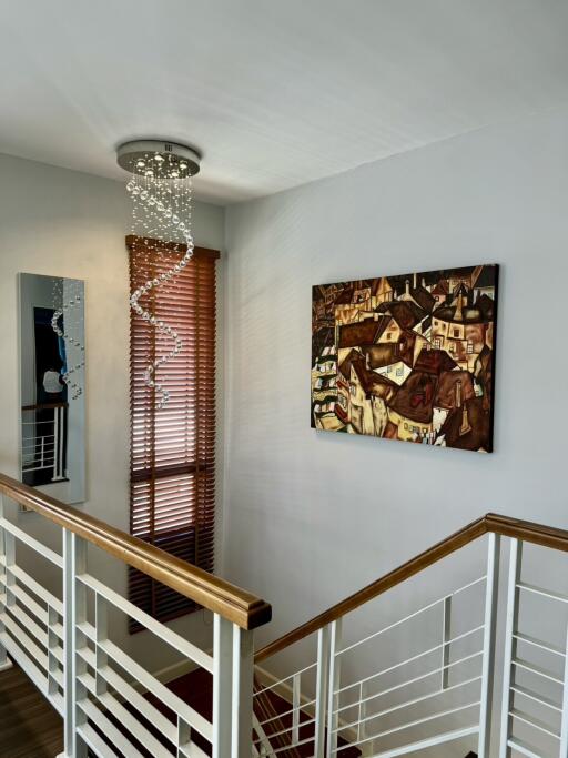 Well-lit staircase with modern chandelier and wall art