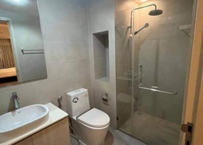 Modern bathroom with sink, toilet, and glass-enclosed shower