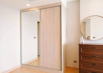 Bedroom with mirror sliding door closet and wooden dresser