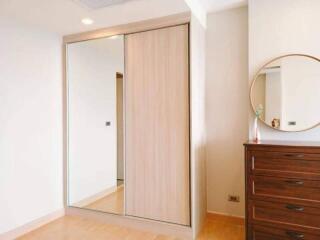 Bedroom with mirror sliding door closet and wooden dresser