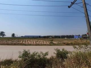 View of open field with road and telephone poles