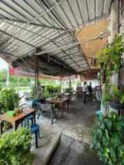 Outdoor seating area with tables and chairs under a covered roof