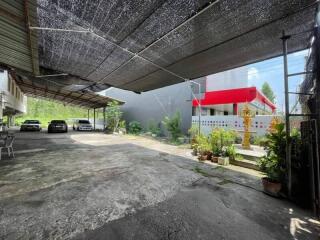 Covered parking area with cars and plants