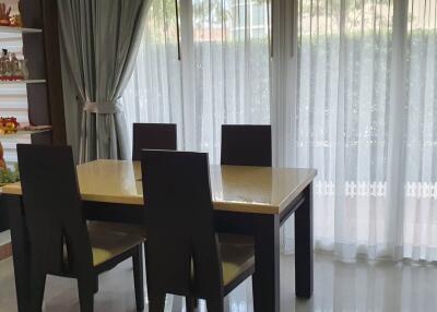 Dining area with table and chairs near large window with curtains