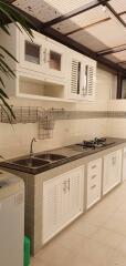 Modern kitchen with tiled backsplash, granite countertops, and white cabinets with both closed and open storage