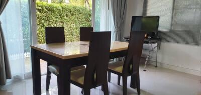 Modern dining area with large windows and garden view