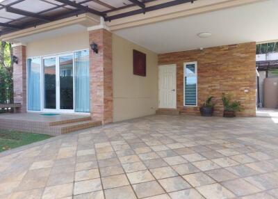 Covered outdoor space with tiled flooring and garden entrance