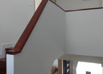 Staircase leading to upper floor with glimpse of dining area and living room