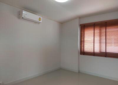 Spacious empty bedroom with window and air conditioning