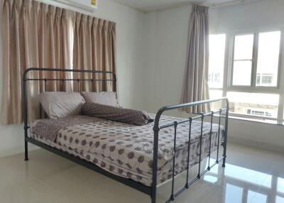 Bright bedroom with metal bedframe and tile flooring