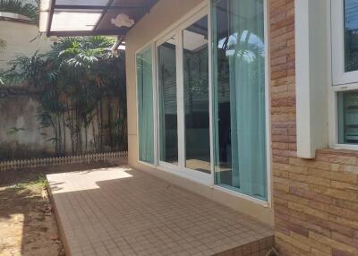Exterior view of patio area with sliding glass doors and tiled floor