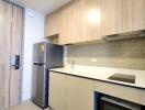 Modern kitchen with wooden cabinets, stainless steel refrigerator, microwave and stovetop