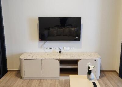 Modern living room with a TV mounted on the wall and a sleek cabinet below it.