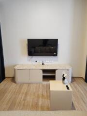 Modern living room with a TV mounted on the wall and a sleek cabinet below it.