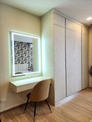 Modern bedroom with a built-in closet and a vanity desk with a chair