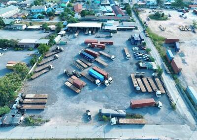 Aerial view of an industrial area with multiple trucks and containers
