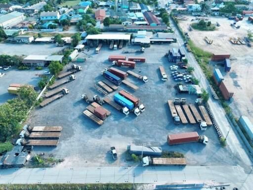 Aerial view of an industrial area with multiple trucks and containers