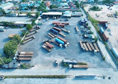 Aerial view of a large outdoor storage facility with multiple trucks and containers
