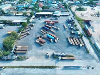 Aerial view of a large outdoor storage facility with multiple trucks and containers