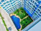 Aerial view of a residential building with a swimming pool and garden area