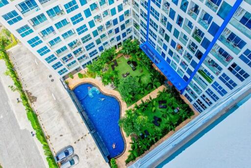 Aerial view of a residential building with a swimming pool and garden area