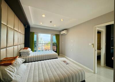 Spacious bedroom with two beds and city view