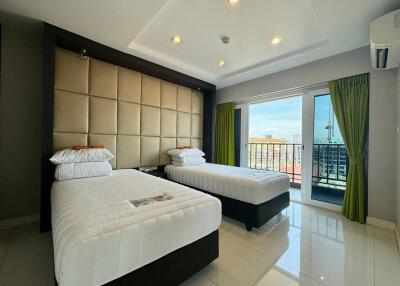 Modern bedroom with two single beds and access to a balcony